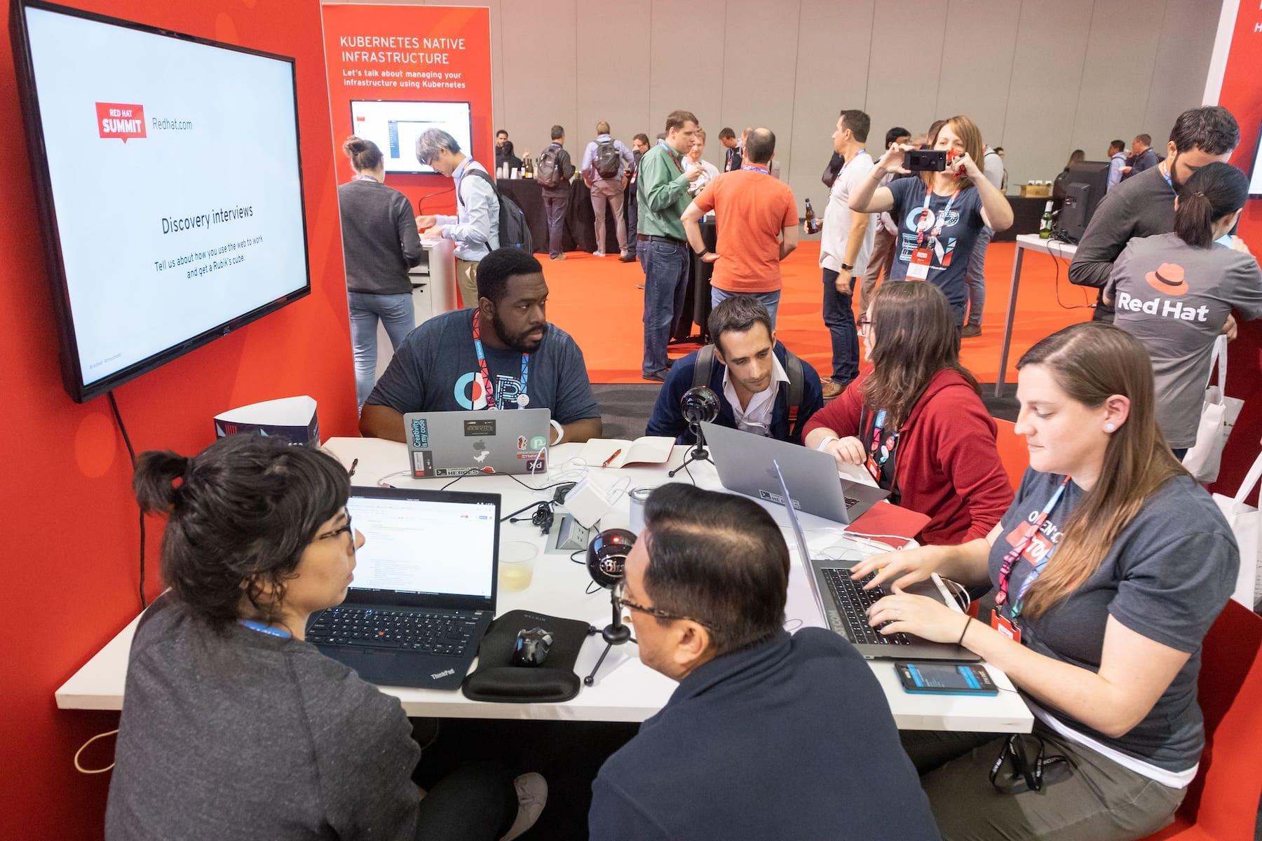 People huddled at a desk at a conference